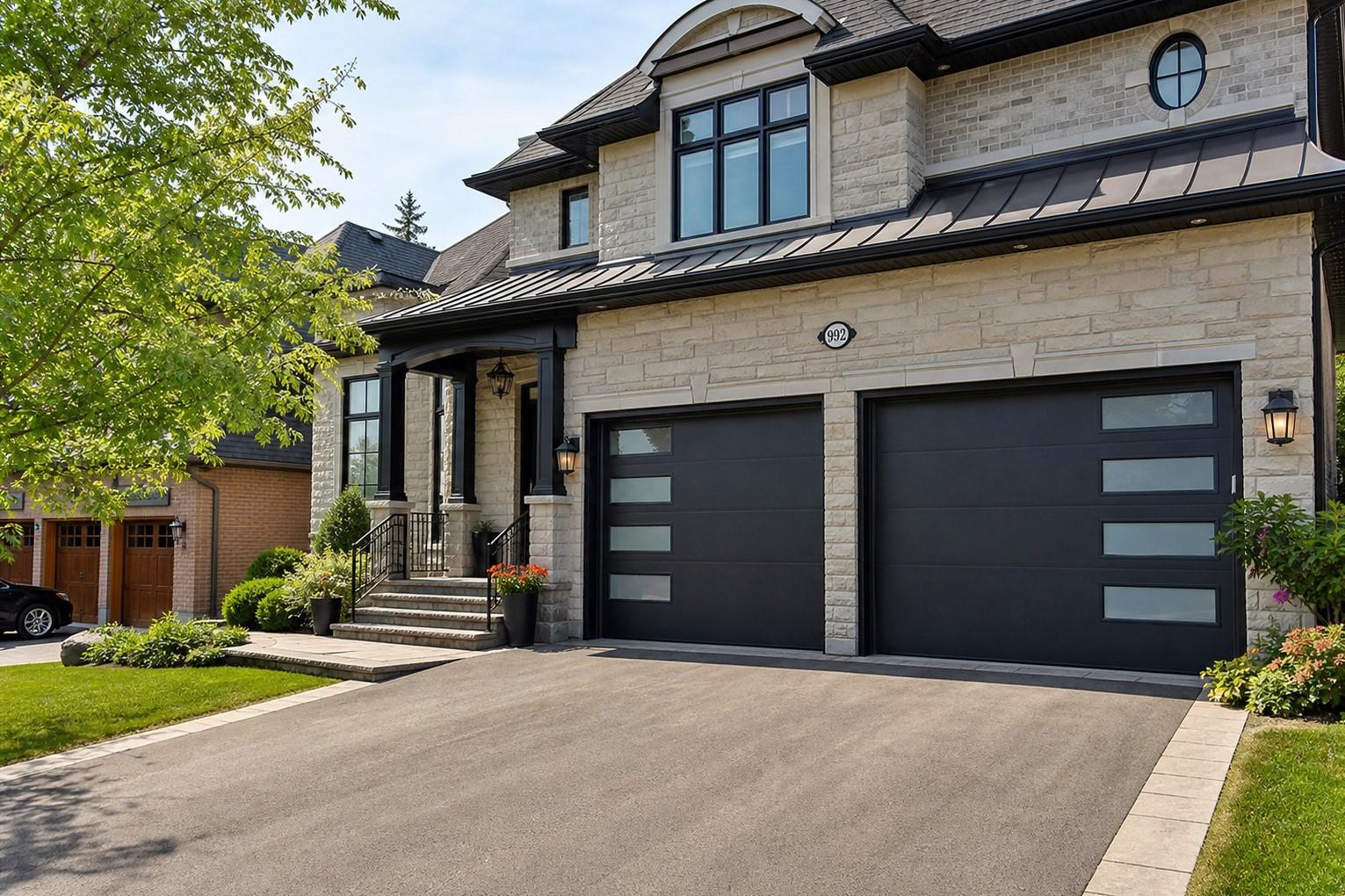 Alex, owner of Pro Garage Doors 2000, stands in front of a modern home with two newly installed matte black garage doors, tool bag in hand.